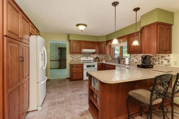 a kitchen with kitchen island a sink stove and refrigerator
