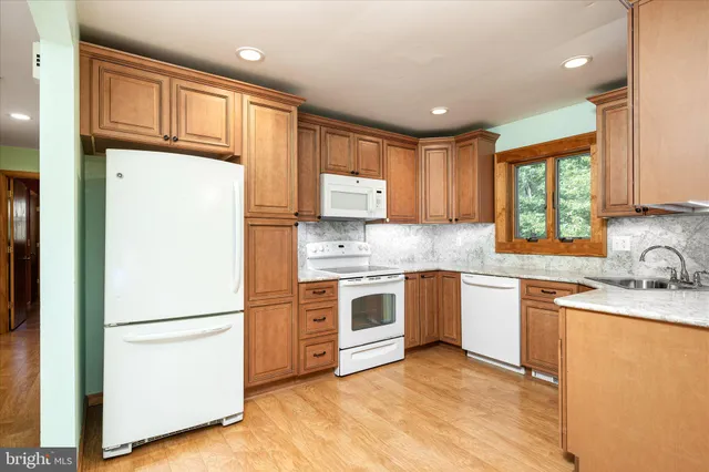 a kitchen with granite countertop stainless steel appliances a refrigerator sink and cabinets