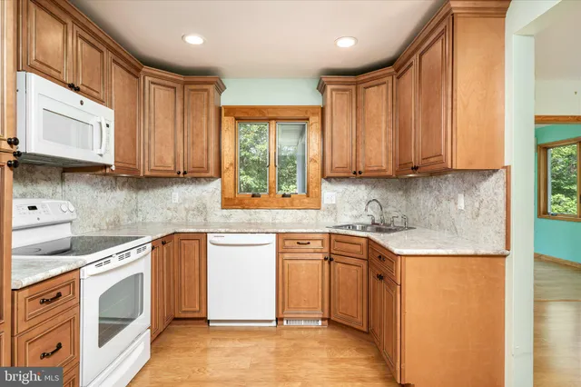 a kitchen with stainless steel appliances granite countertop a sink stove and cabinets