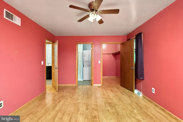 a view of a livingroom with a chandelier fan and a window