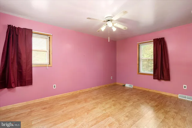 a bedroom with a bed and a chandelier fan