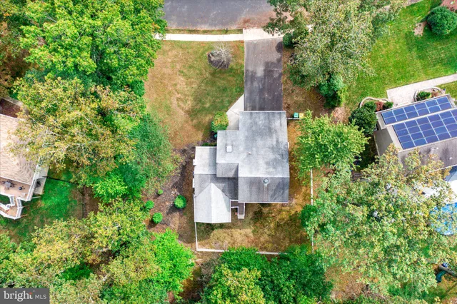 an aerial view of residential house with outdoor space and trees all around