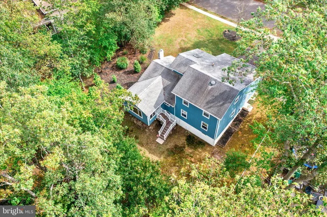 an aerial view of a house with a yard and large trees