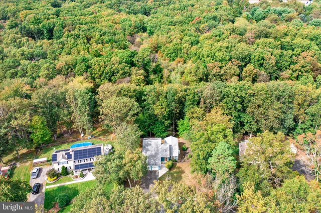 an aerial view of residential houses with outdoor space and trees