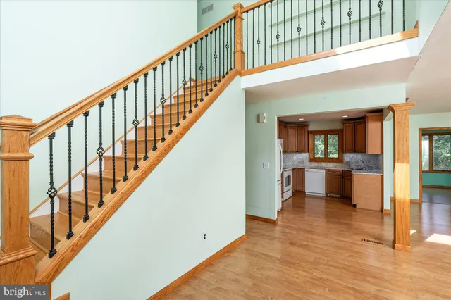 a view of staircase with white walls and a dining table