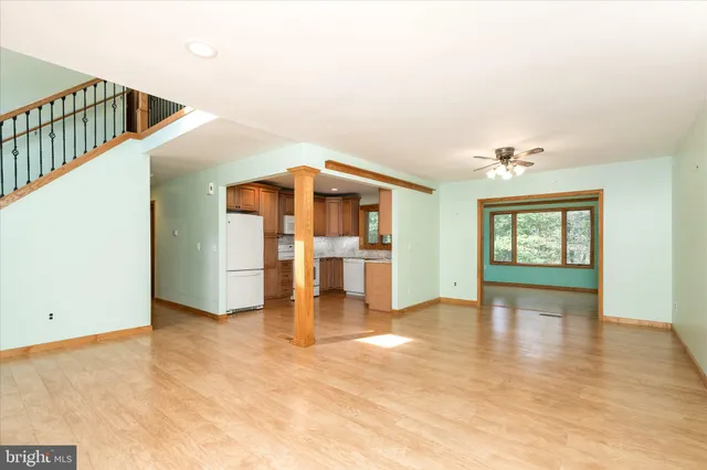 a view of an empty room with window and wooden floor