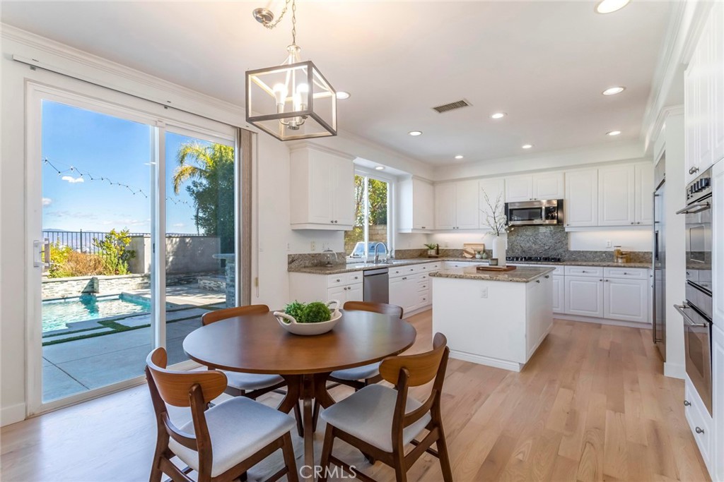 26413 Ocasey Place Stevenson Ranch, CA 91381 - Photo 23 of 75 a kitchen with a dining table chairs and refrigerator