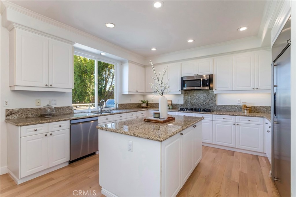 26413 Ocasey Place Stevenson Ranch, CA 91381 - Photo 24 of 75 a kitchen with stainless steel appliances granite countertop a stove a sink and a microwave