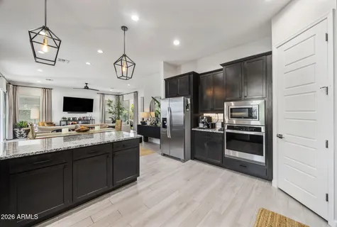 a kitchen with stainless steel appliances a refrigerator and a kitchen island
