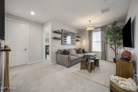 a living room with furniture a flat screen tv and a window