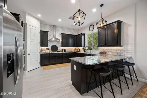a kitchen with stainless steel appliances kitchen island granite countertop a sink a stove and a refrigerator