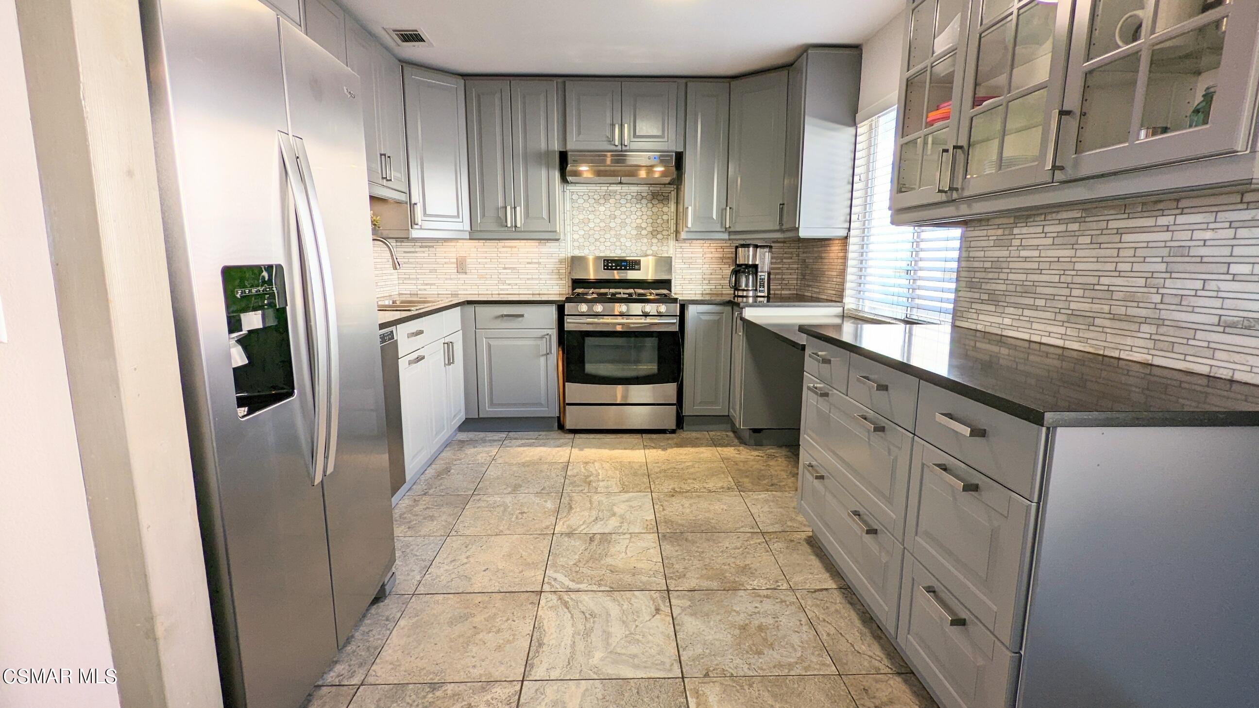 9758 Vía Roma Burbank, CA 91504 - Photo 4 of 8 a kitchen with stainless steel appliances granite countertop a refrigerator and a sink