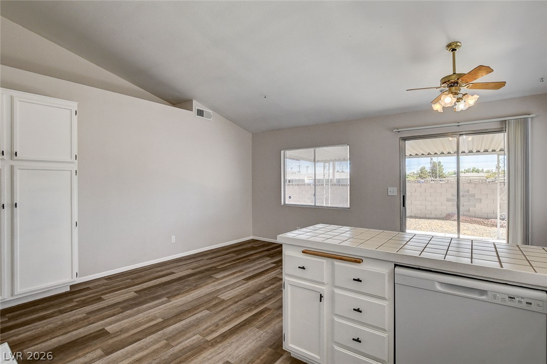6209 Warm River Road Las Vegas, NV 89108 - Photo 18 of 39 A vibrant open-concept space features plank flooring, ample cabinetry, and a ceiling fan.