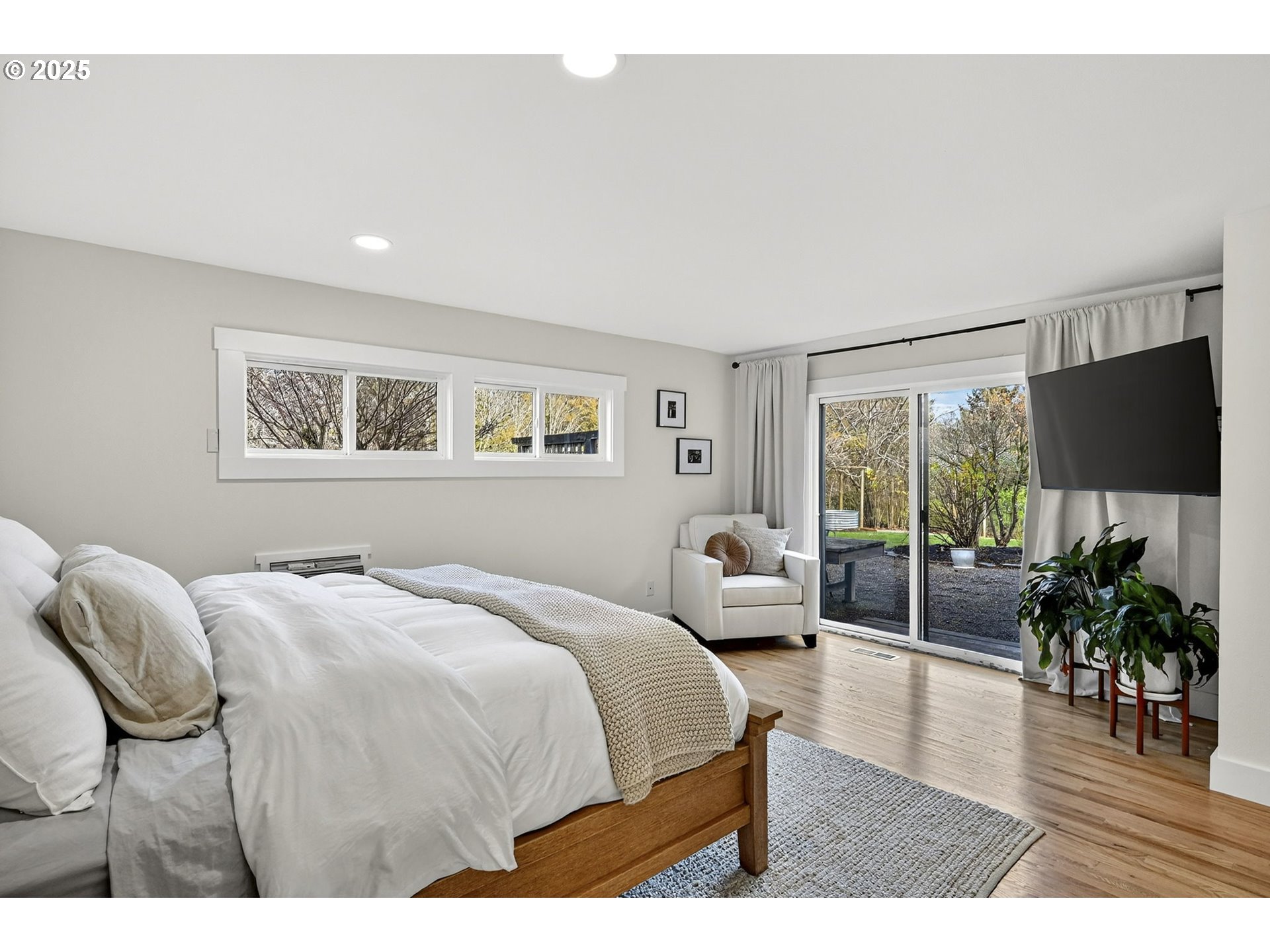 13162 Northwest McNamee Road Portland, OR 97231 - Photo 22 of 48 a bedroom with a bed a large window and wooden floor