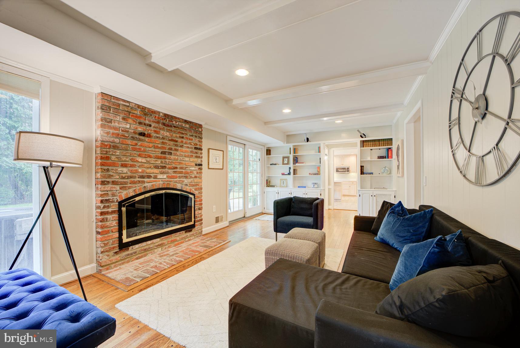 9116 Wooden Bridge Road Potomac, MD 20854 - Photo 9 of 22 a living room with furniture a fireplace and a flat screen tv