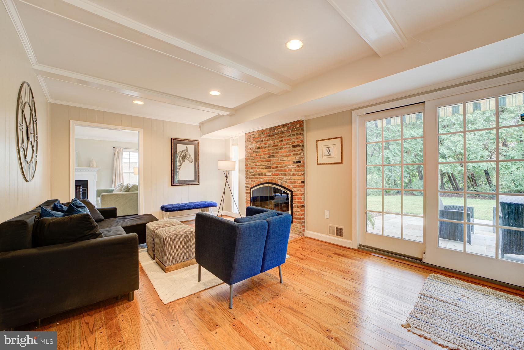 9116 Wooden Bridge Road Potomac, MD 20854 - Photo 10 of 22 a living room with furniture a fireplace and a floor to ceiling window