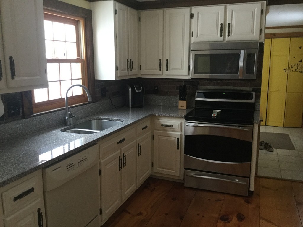 35 Downey Street Hopkinton, MA 01748 - Photo 4 of 28 a kitchen with granite countertop a sink stove and microwave