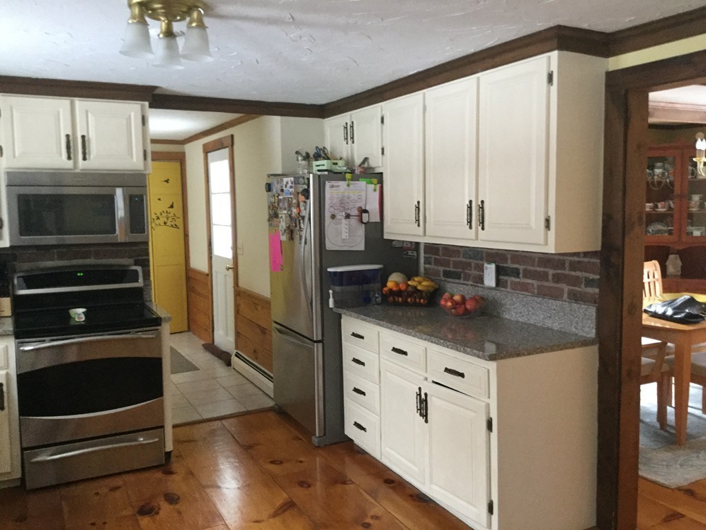 35 Downey Street Hopkinton, MA 01748 - Photo 5 of 28 a kitchen with stainless steel appliances granite countertop a stove a refrigerator and a microwave