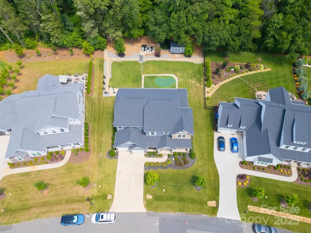 an aerial view of residential houses with outdoor space and street view