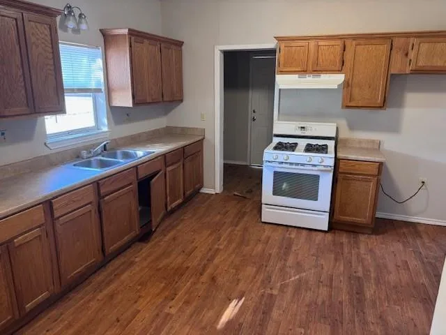 a kitchen with stainless steel appliances granite countertop a stove a sink and a refrigerator