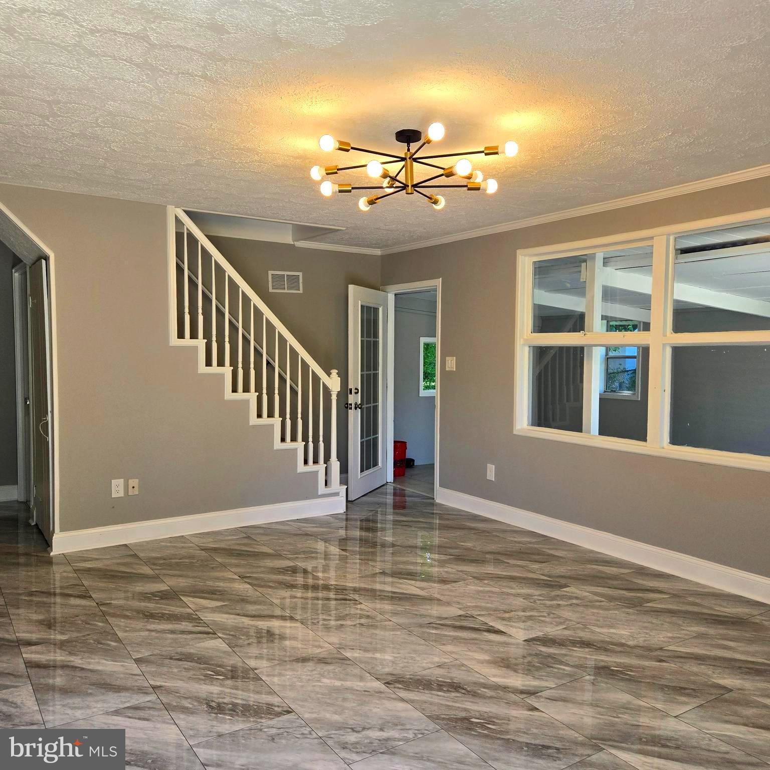 9711 Dilston Road Silver Spring, MD 20903 - Photo 11 of 44 a view of an empty room with chandelier fan and wooden floor