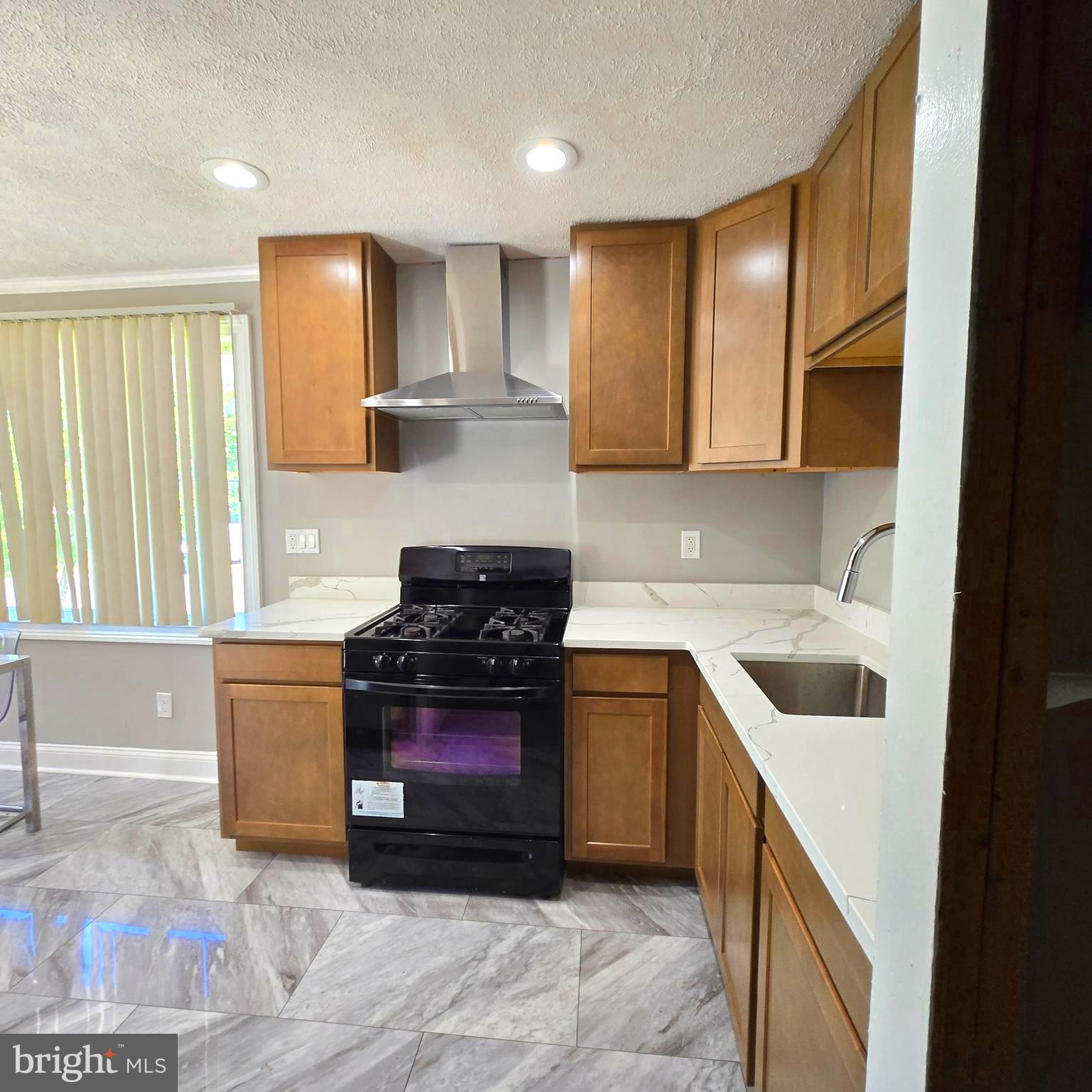 9711 Dilston Road Silver Spring, MD 20903 - Photo 18 of 44 a kitchen with a sink a stove and cabinets