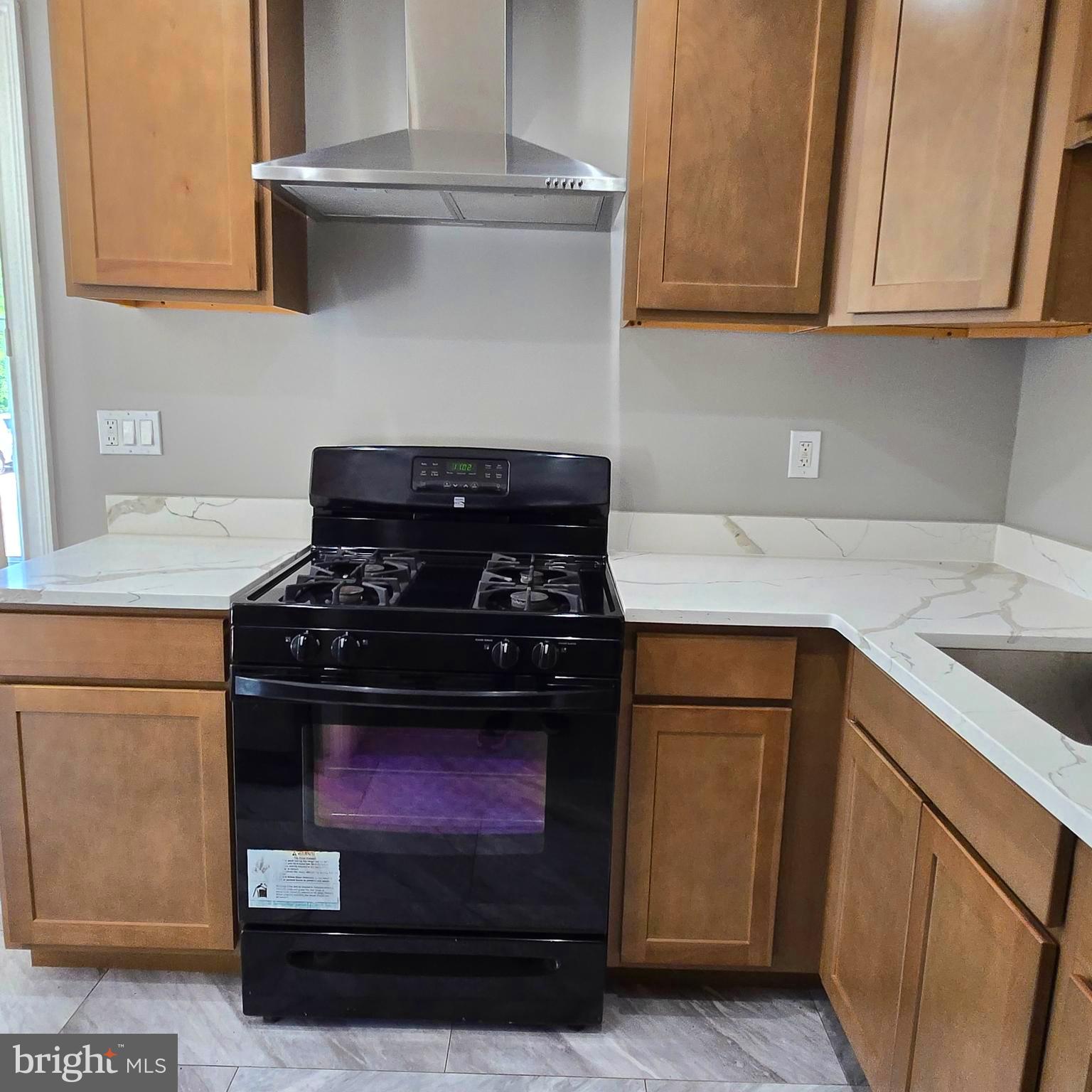9711 Dilston Road Silver Spring, MD 20903 - Photo 21 of 44 a kitchen with stainless steel appliances granite countertop a stove a sink and a microwave