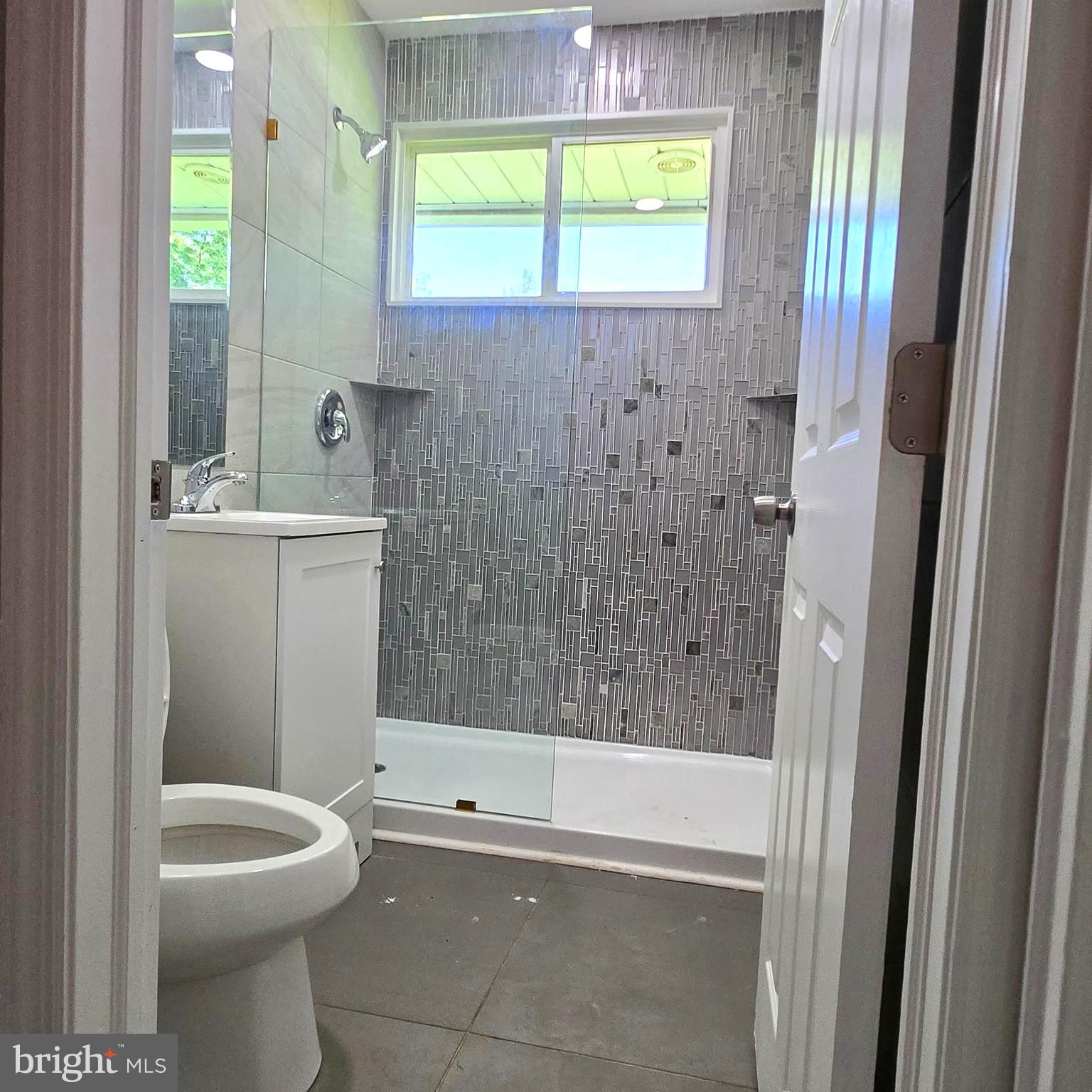 9711 Dilston Road Silver Spring, MD 20903 - Photo 27 of 44 a bathroom with a granite countertop toilet a sink and bathtub