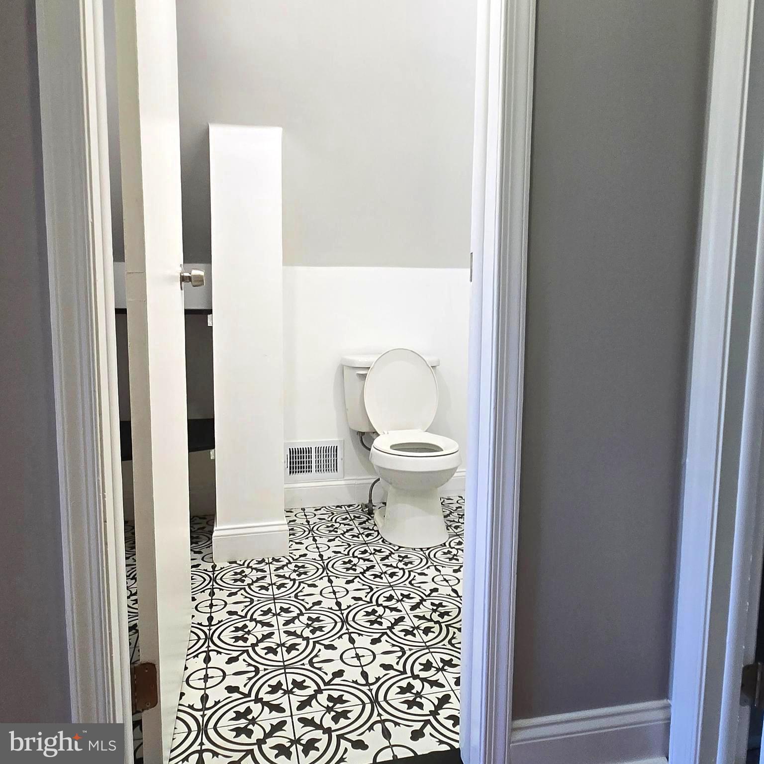 9711 Dilston Road Silver Spring, MD 20903 - Photo 35 of 44 a bathroom with a toilet and a shower curtain