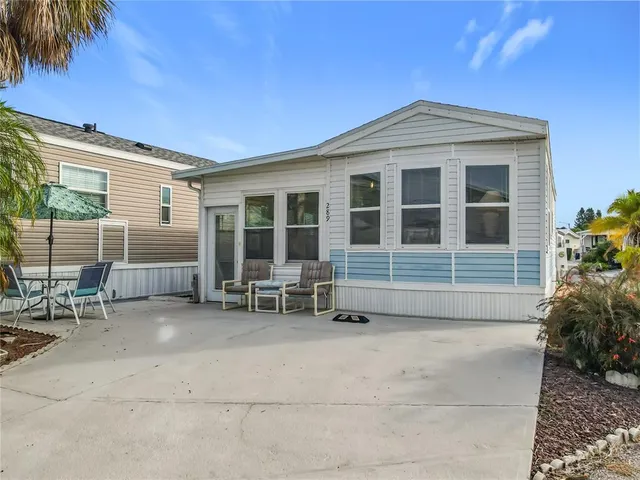 a front view of a house with outdoor seating and barbeque oven