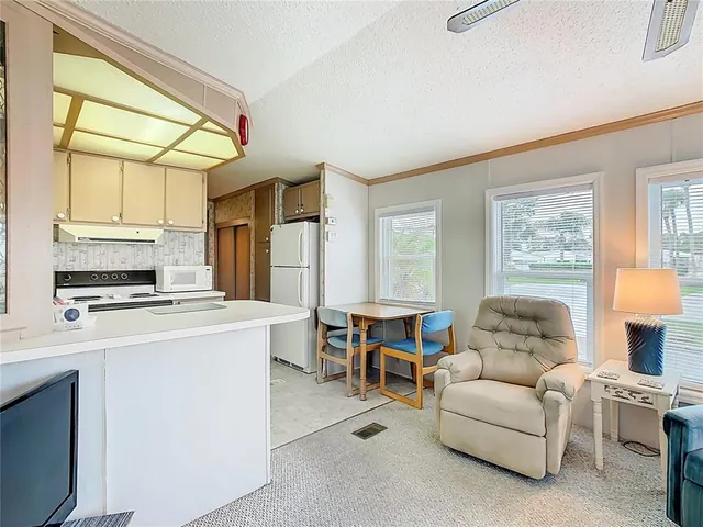 a living room with furniture a flat screen tv and a table