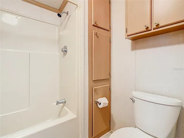 a white toilet sitting next to a bath tub