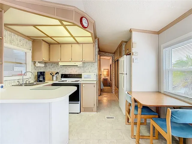 a kitchen with a refrigerator and a stove top oven