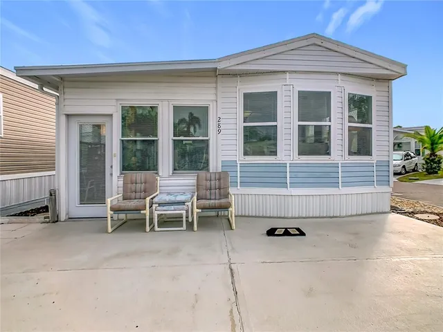 a view of a house with a chairs and table in a patio
