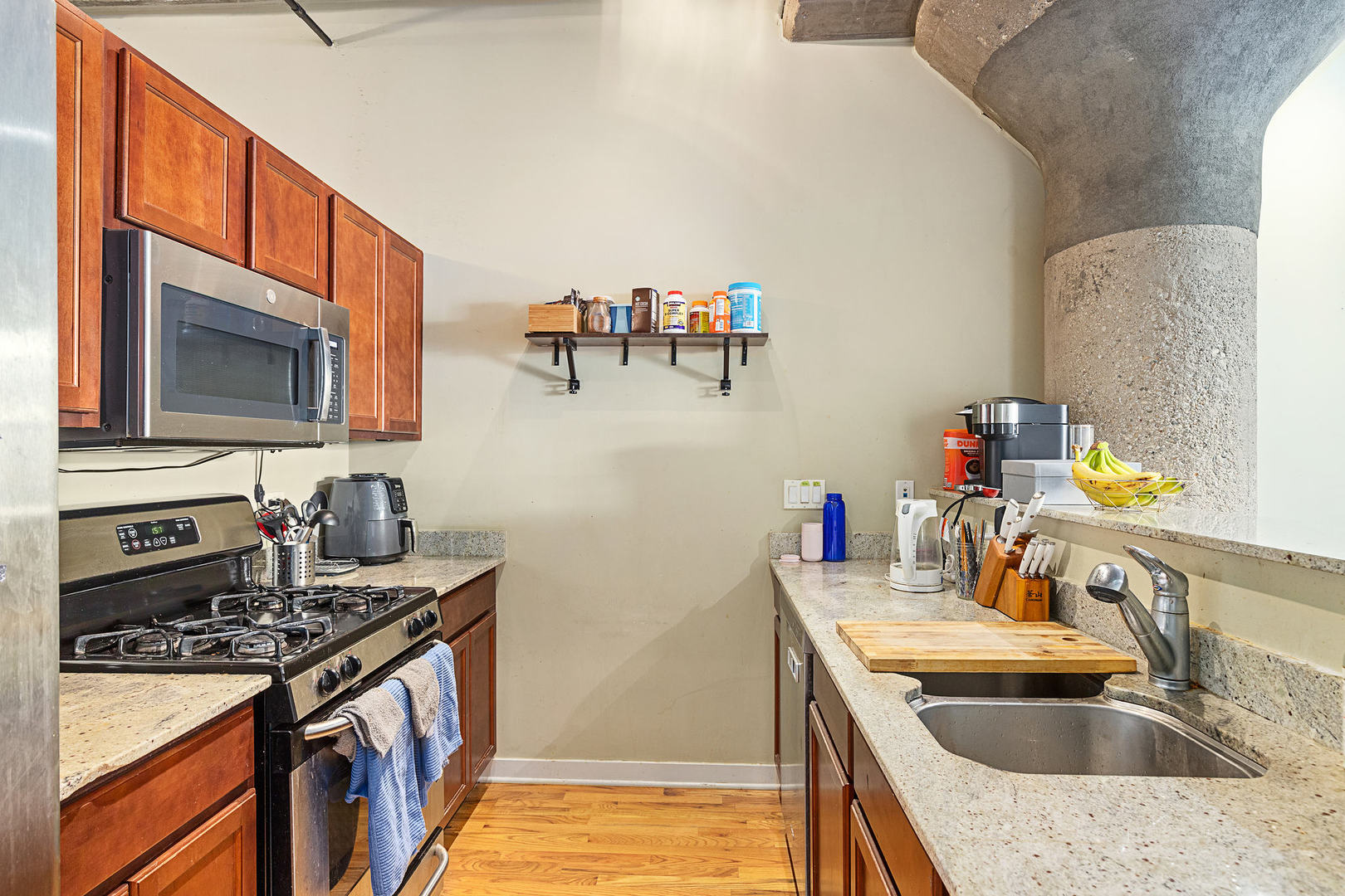 1111 West 15th Street, Unit 235 Chicago, IL 60608 - Photo 11 of 21 a kitchen with a sink stove top oven and microwave