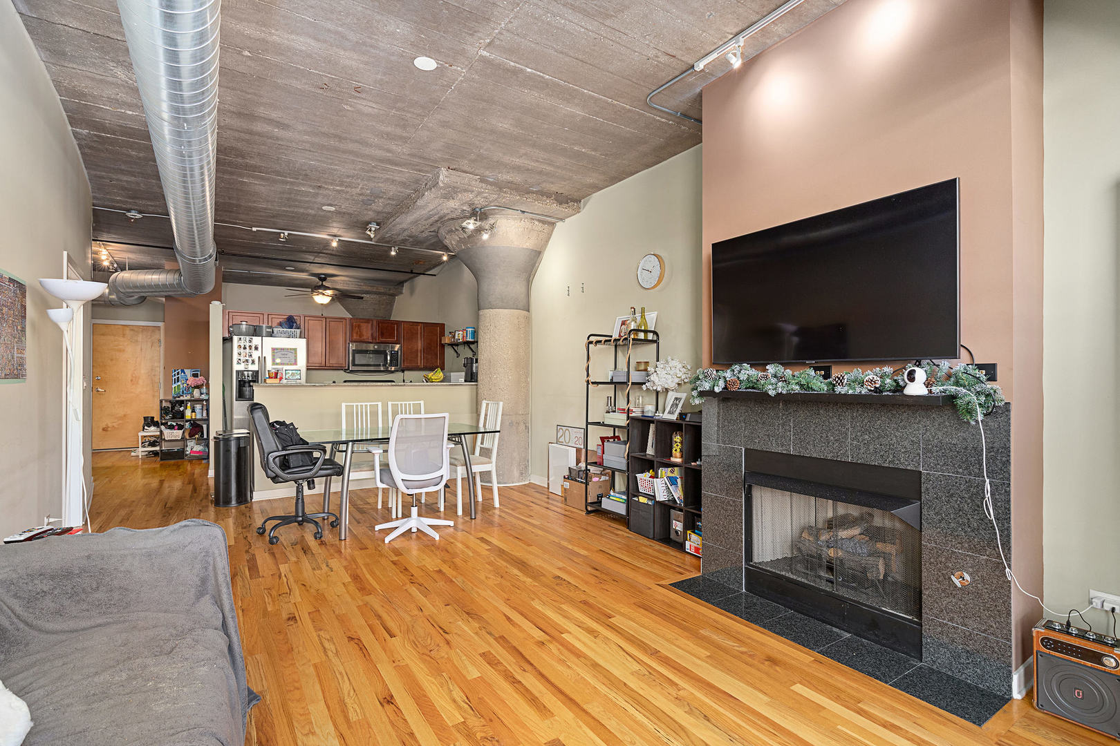 1111 West 15th Street, Unit 235 Chicago, IL 60608 - Photo 8 of 21 a living room with furniture a flat screen tv and a fireplace