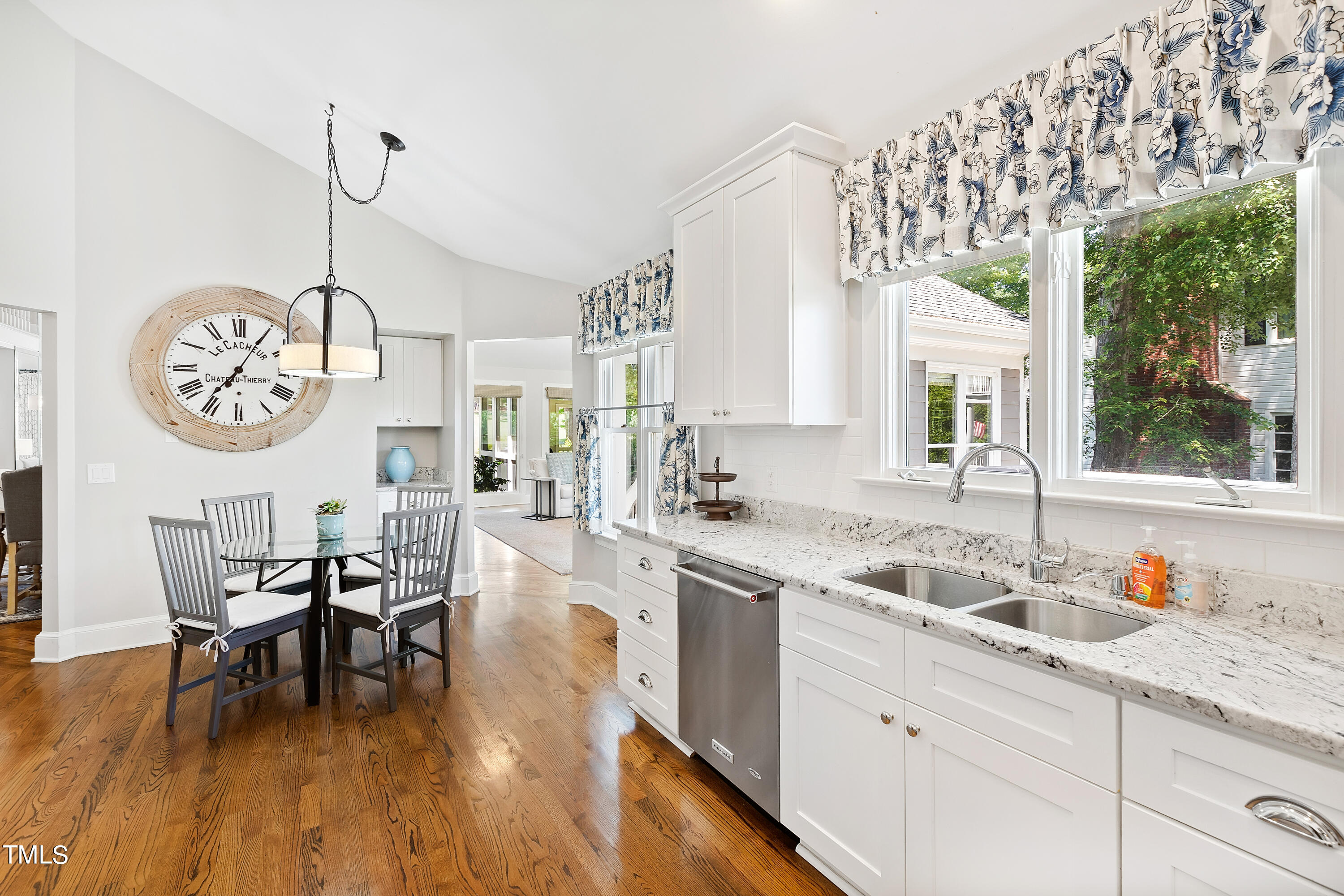 1605 Quaker Ridge Point Raleigh, NC 27615 - Photo 15 of 54 a kitchen with stainless steel appliances granite countertop a sink a stove a dining table and chairs with wooden floor