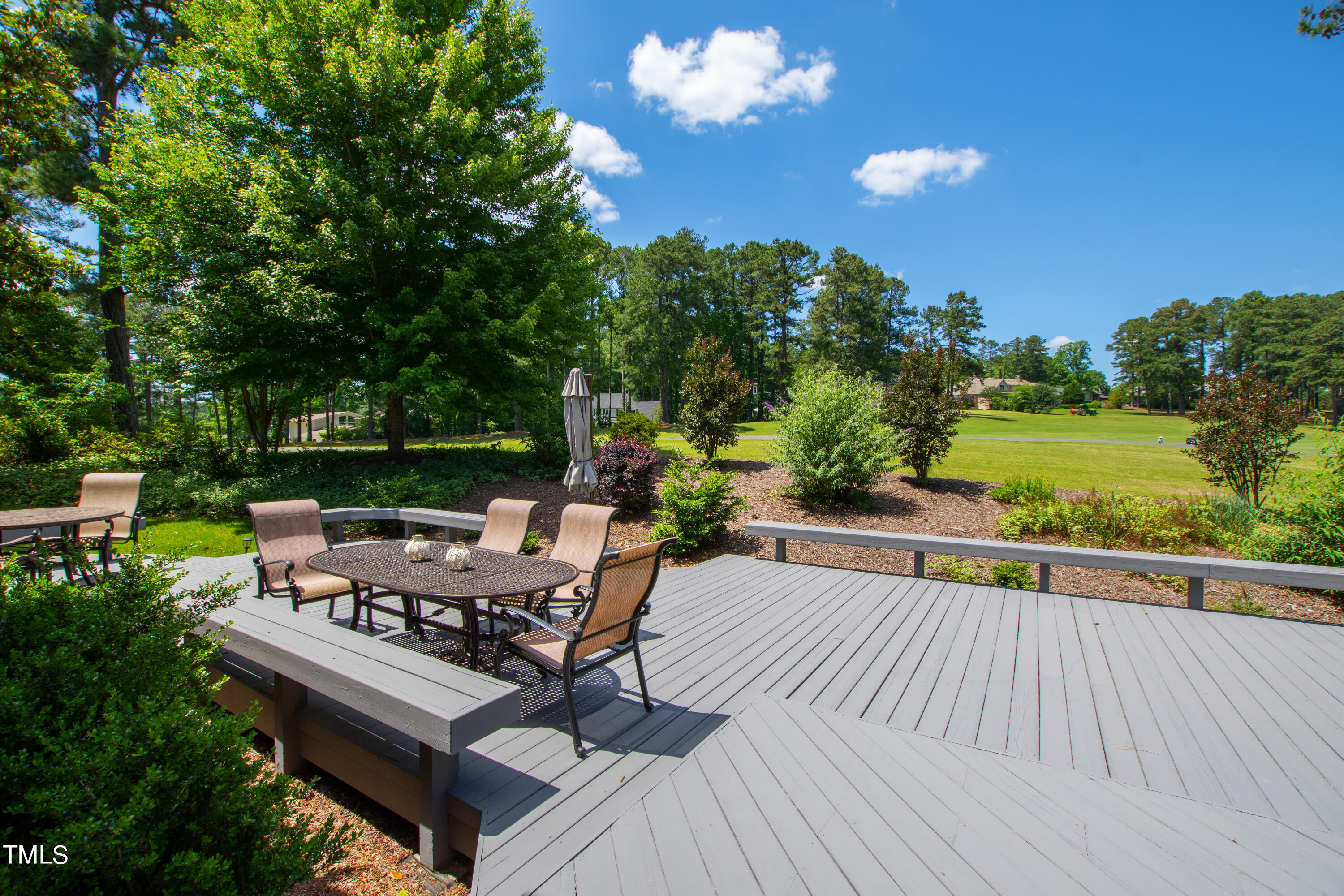 1605 Quaker Ridge Point Raleigh, NC 27615 - Photo 40 of 54 a view of a patio with dining table and chairs with wooden floor and fence