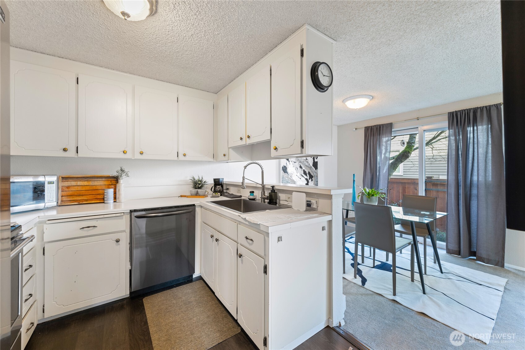 242 4th Avenue South, Unit 2 Edmonds, WA 98020 - Photo 11 of 34 a kitchen with a stove a sink a dining table and chairs