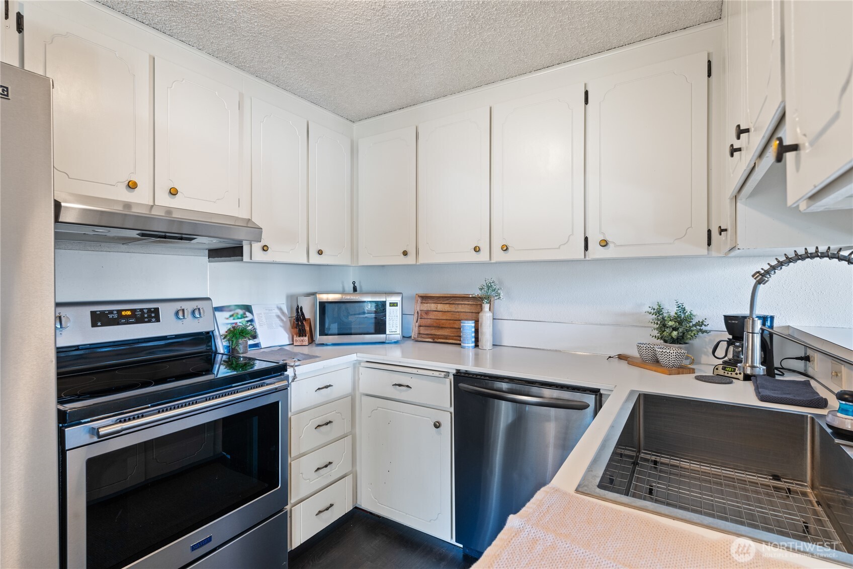242 4th Avenue South, Unit 2 Edmonds, WA 98020 - Photo 9 of 34 a kitchen with white cabinets and appliances