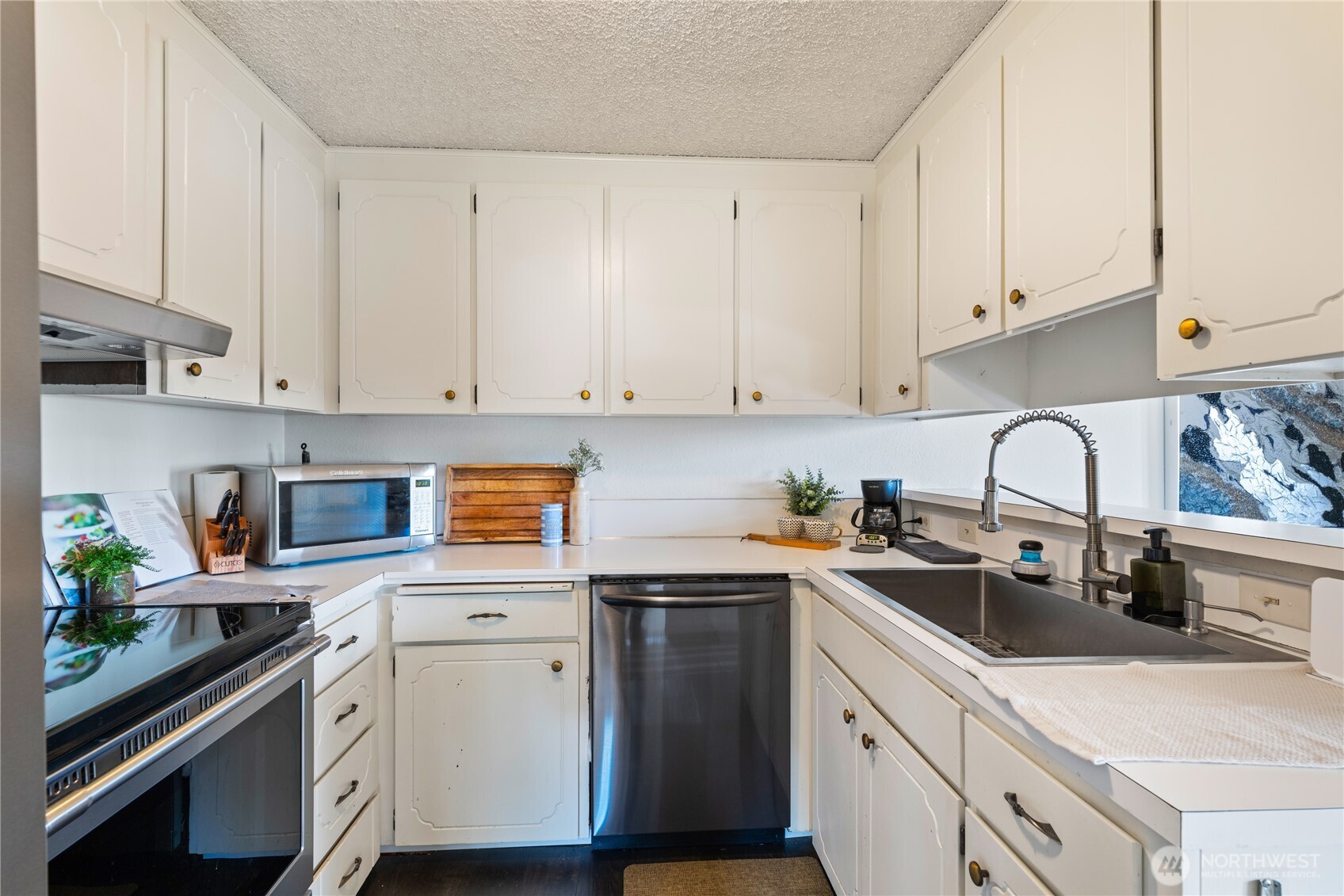 242 4th Avenue South, Unit 2 Edmonds, WA 98020 - Photo 10 of 34 a kitchen with white cabinets and white appliances