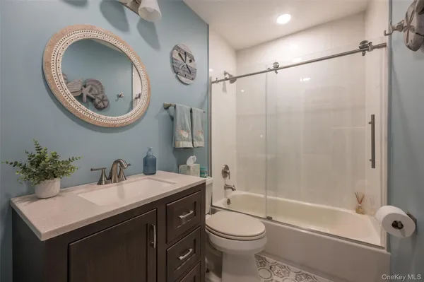 a bathroom with a sink mirror vanity and toilet
