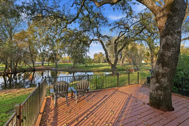 a view of an empty room with stairs and chandelier fan