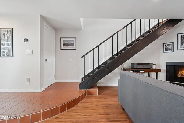 a view of a hallway with wooden floor and a bathroom