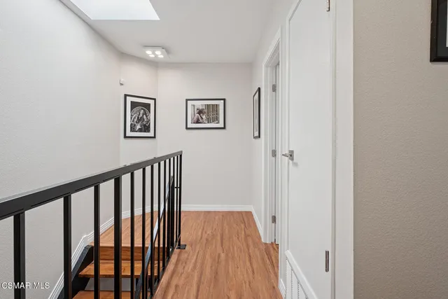 a view of a hallway with wooden floor and staircase