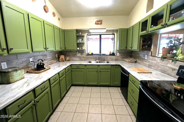 a kitchen with a sink a stove cabinets counter space and a window