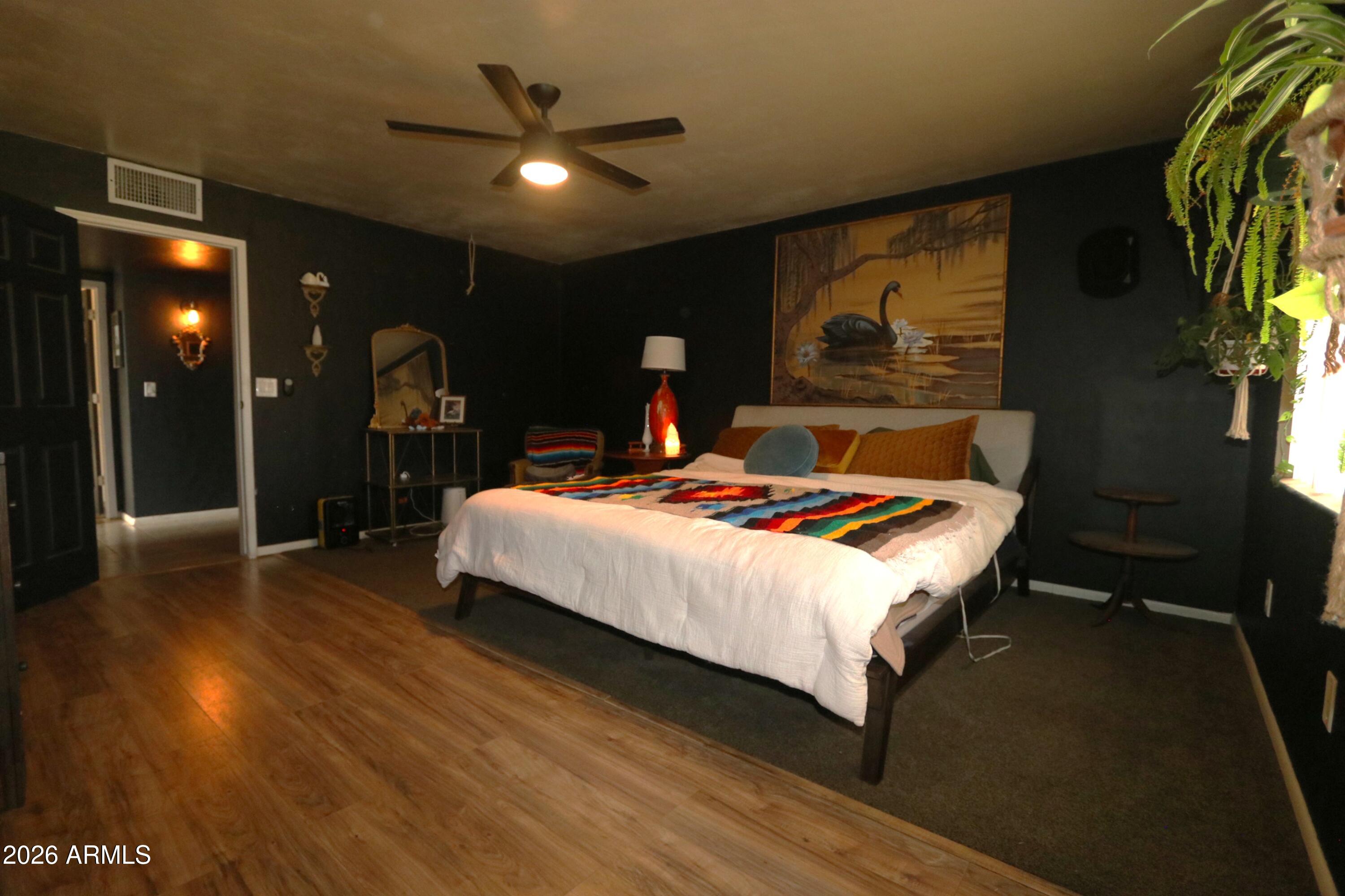 11870 Fort Grant Road Willcox, AZ 85643 - Photo 21 of 44 a bedroom with a bed and lamp on desk with wooden floor