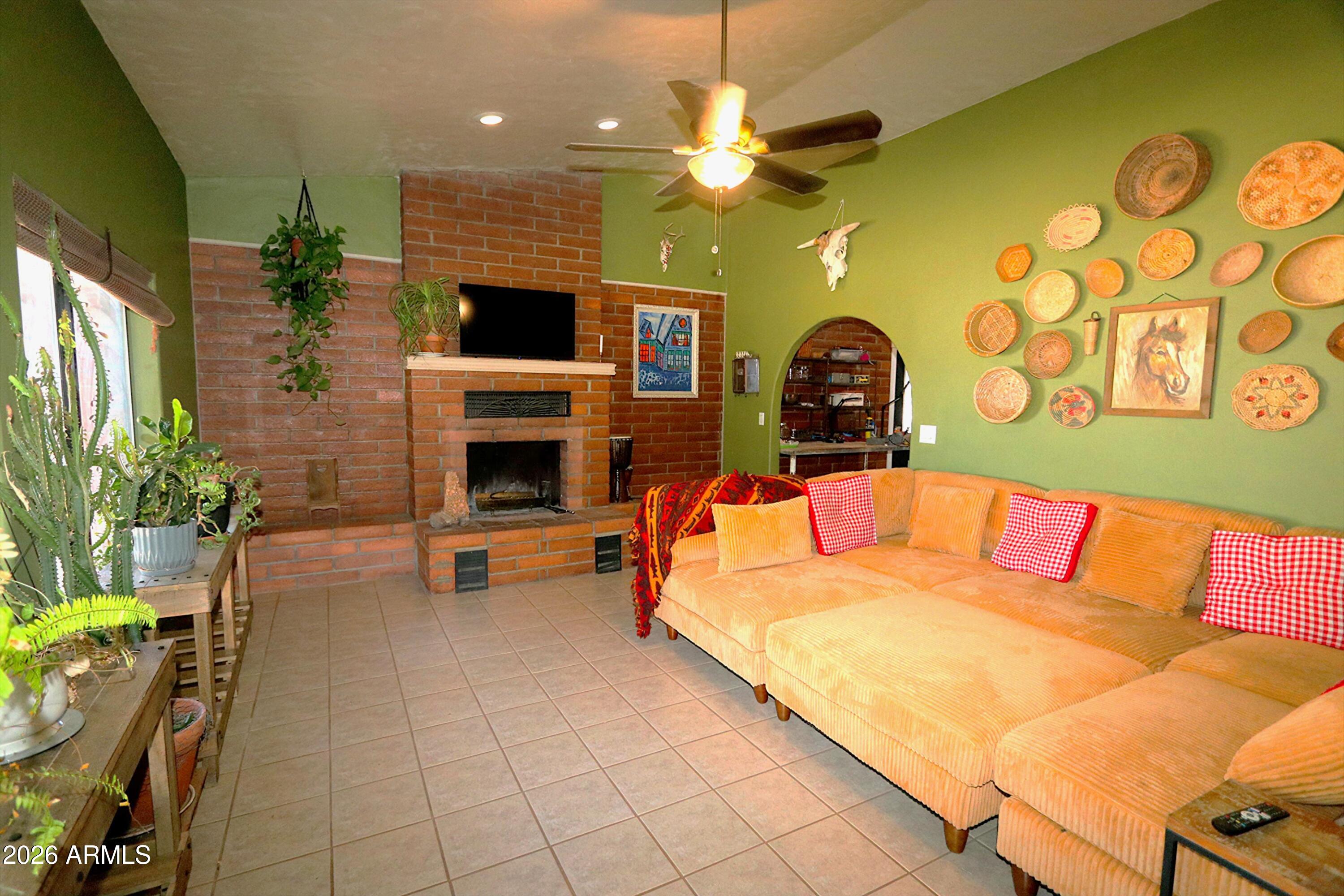 11870 Fort Grant Road Willcox, AZ 85643 - Photo 8 of 44 a living room with furniture a flat screen tv and a fireplace