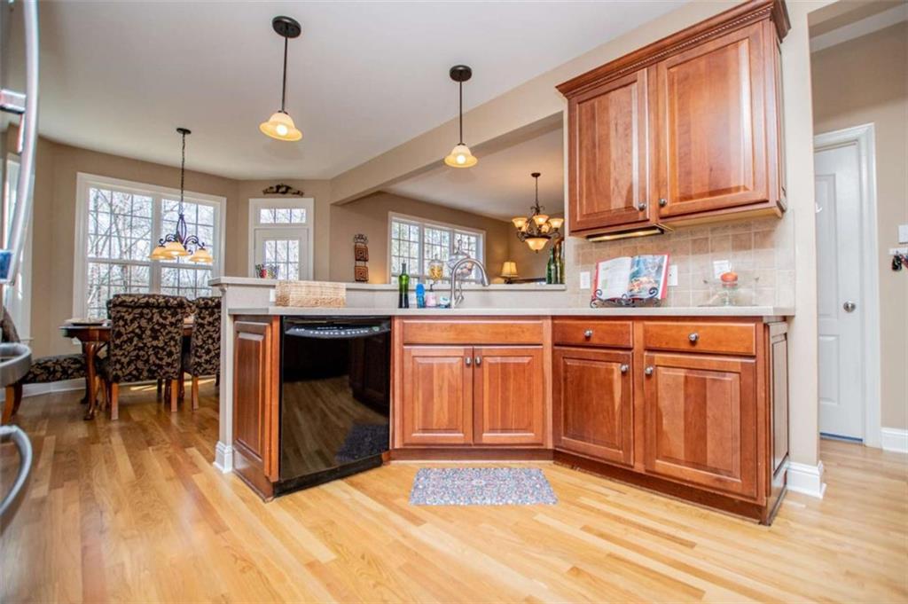 6170 Hedgestone Way Douglasville, GA 30135 - Photo 16 of 106 a kitchen with stainless steel appliances granite countertop a refrigerator a sink dishwasher a dining table and chairs with wooden floor