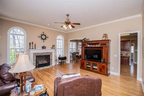 a kitchen with stainless steel appliances granite countertop a refrigerator a sink dishwasher a stove and white countertops with wooden floor